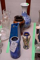 Group shot of five vases displayed on table with green tape markings
