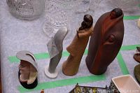 Four ceramic figurines including terracotta woman, elongated grey Rosenthal figurine, painted female bust, and ceramic match box holder.