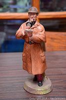 Front view showing detective holding magnifying glass, notebook, and pipe