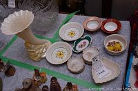 Full lot view with Belleek Rock spill vase, heart dish, and assorted decorative dishes set on table.