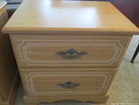 Front view showing top and two of the three drawers with metal pulls and routed detail