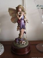 Front view of resin fairy figurine on wooden music box base