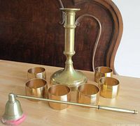candlestick, six napkin rings, snuffer displayed on table