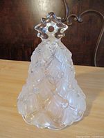 Front view of clear pressed glass Christmas tree-shaped bell with star handle