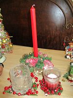 Wreath candle holder with red taper and two glass votive holders displayed together
