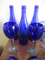 Group view showing three cobalt blue bottles and two wine glasses
