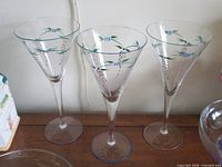 Three hand painted flared champagne glasses on tabletop