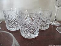 Three cut crystal rocks glasses side by side showing pattern and size