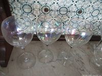 Three iridescent balloon wine glasses on marble surface