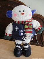 Front view of plush snowman showing clothing and accessories