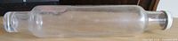 Full view of clear glass rolling pin with cap