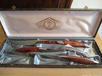 Open presentation box displaying three-piece carving set
