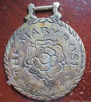 Front view of brass showing Tudor rose and lettering
