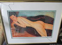 Front view of framed Modigliani reclining nude print, showing broken glass