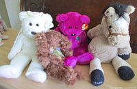 Group shot of four Ty plush toys: rabbit, horse, magenta bear, brown floppy plush