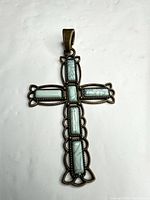 Front view of brass cross pendant with faux turquoise inlays