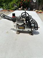 Front view of Central Pneumatic compressor showing logo and coiled hose