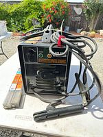 Front view of welder, leads, stinger, electrode packs visible