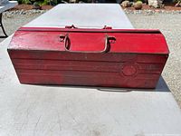 Closed red steel toolbox, front view