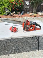 Chainsaw and earmuffs on table, full view of bar