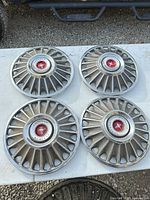 All four Mustang hubcaps arranged on table