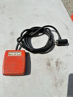 Top view of red/orange Gorlitz foot switch with black cord