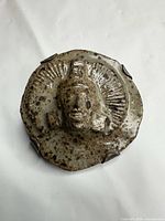 front view showing figural head motif and glazed surface