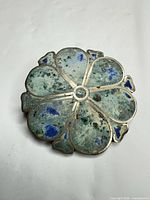 Front view of silver-plated floral brooch with turquoise chip inlay