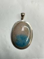 Front view of sterling silver oval pendant with cabochon