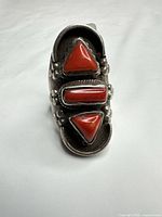 Front view showing three red coral stones and silver décor