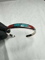 Top view of sterling cuff showing alternating turquoise and red stone inlays