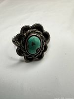 Front view showing turquoise cabochon and scalloped silver frame