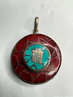 Front view showing red mosaic and central turquoise inlay with symbol