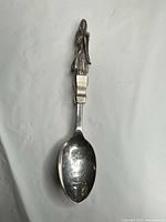 Full view of spoon showing engraving and figural handle