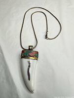 Full view of pendant necklace showing horn pendant and chain