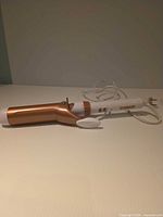 Full view of curling iron showing barrel, handle and cord