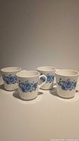 All four CorningWare mugs grouped to show quantity and overall condition