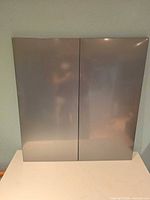 Front view of both grey metal magnetic boards showing glossy finish