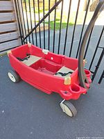 Side view of red Step2 wagon showing folding handle, side door and cup holders