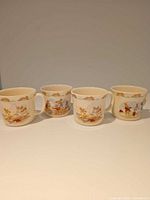 Front view of four matching Bunnykins cups