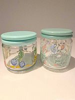 Both jars side by side showing painted designs and lids