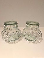Both glass jars side by side showing overall form and closures
