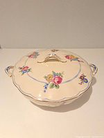 Top view of closed tureen showing floral pattern, blue swag and gold rim