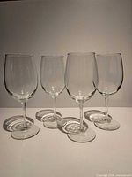 Front view of four white wine glasses