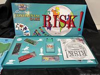 Open box showing game board, plastic armies, cards, dice and rulebook