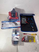 Lot overview showing boxed sets, multimeter kit, screwdriver stand