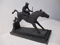 Full view left side of metal horse and rider sculpture on marble base