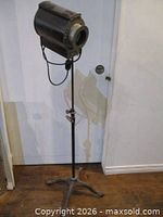 Full view of spotlight mounted on tall cast iron stand