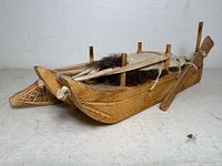 Front oblique view showing sled prow, snowshoe, rifle, canvas cover and fur cargo