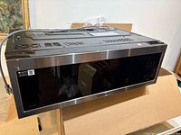 Front and top view of Samsung MVEM1825 microwave showing stainless trim, black glass door and control panel